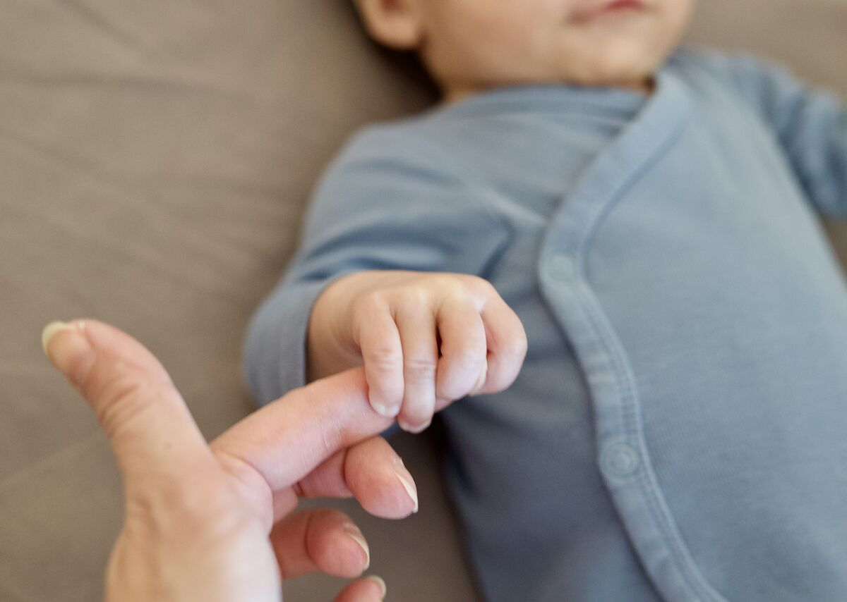 Baby gripping a parent's finger